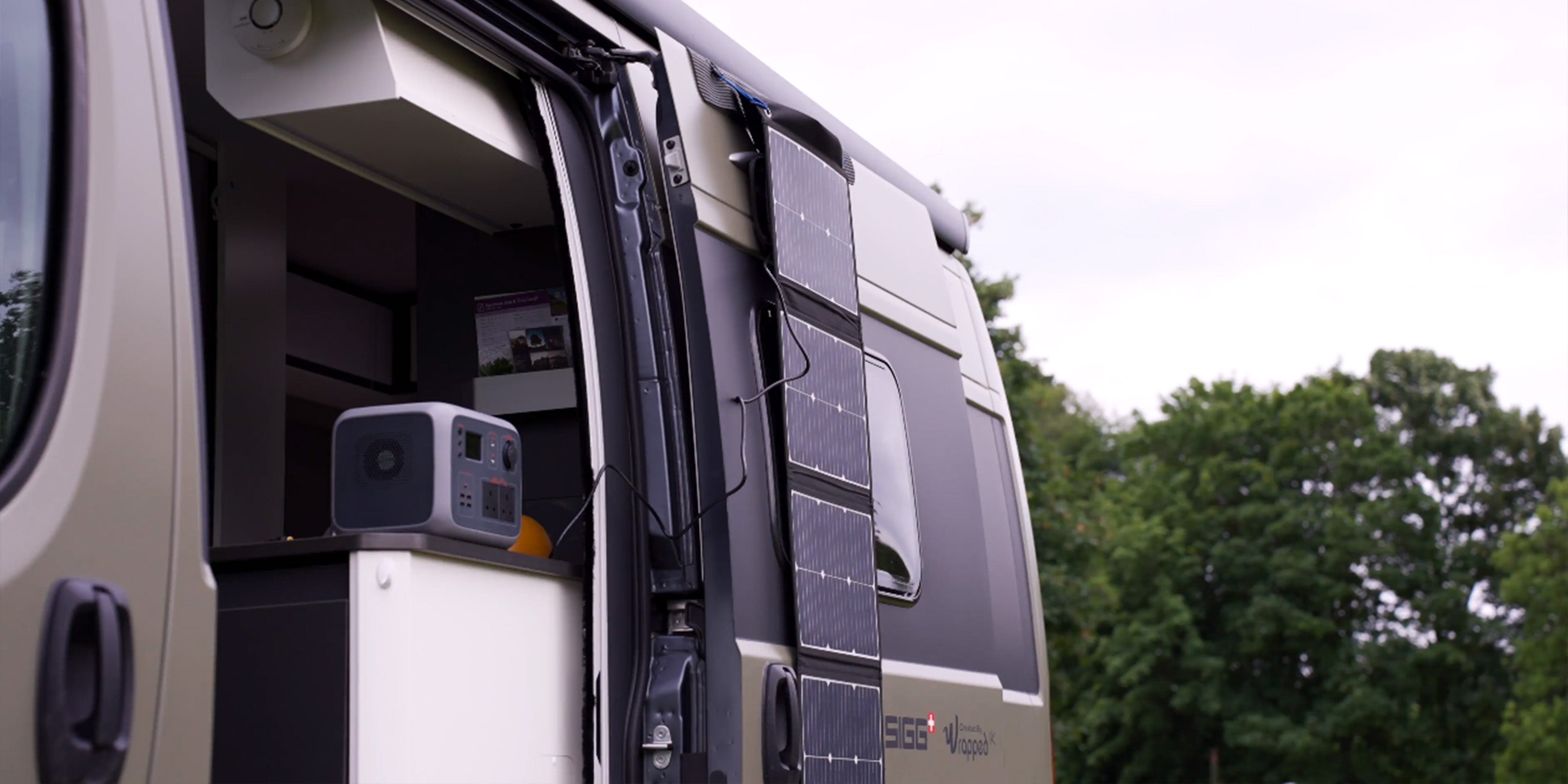 Image of the TS100 solar panel charging a TP500 while hanging off the side of a vehicle door